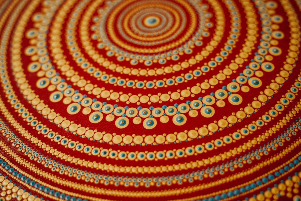 Close-up of a vibrant dot painting with intricate patterns and warm color scheme
